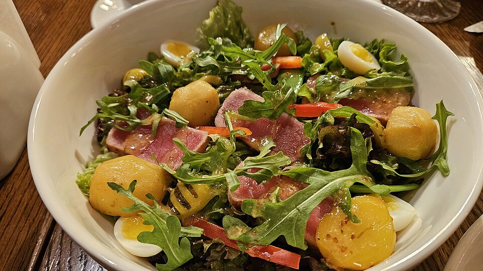 Salade niçoise — raw vegetables, anchovy or tuna, and no lettuce.