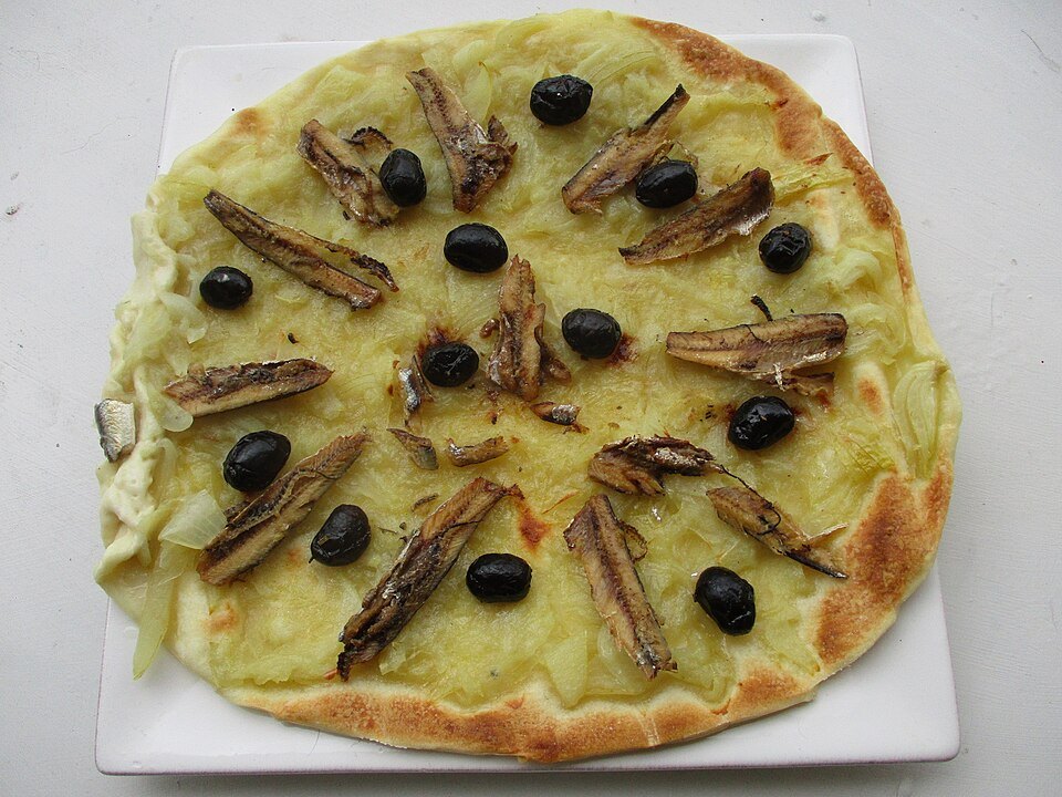 Pissaladière — onion tart with anchovy and olives. No cheese, no tomato.